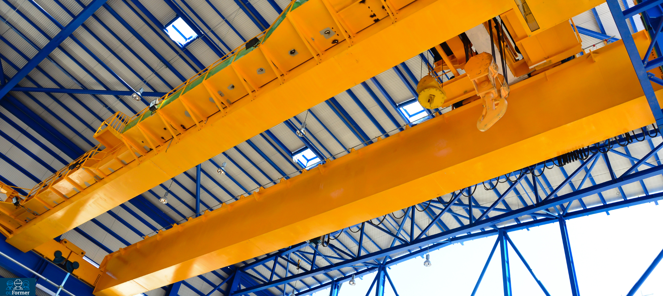 Pont roulant suspendu en atelier : le pont circule sur des chemins de roulement fixés en hauteur, sans structure au sol.