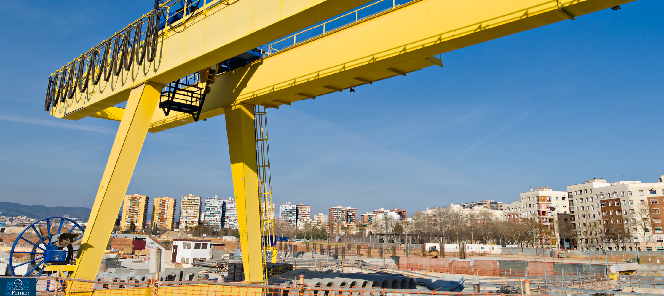 Portique de levage installé en extérieur : la structure repose sur deux palées au sol et permet de déplacer des charges lourdes sur une large zone de travail.
